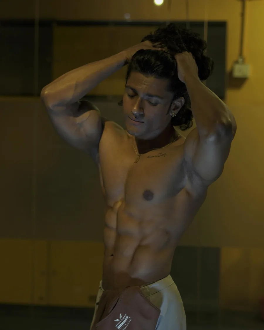 Rajdeep with arms up under warm gym light