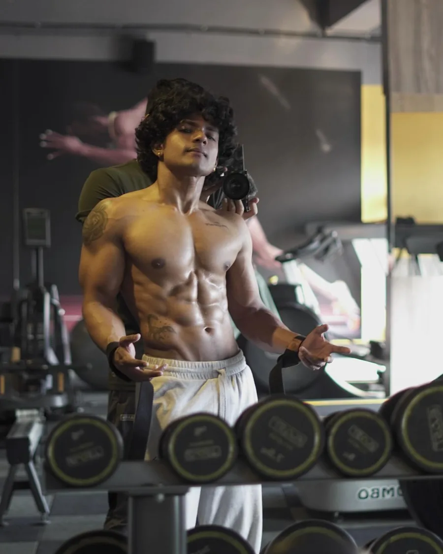 Rajdeep shirtless by the dumbbell rack